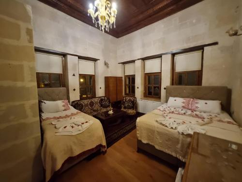 a room with two beds and a couch and windows at Born Hotel in Urgup