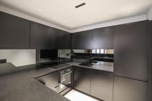 une cuisine avec des armoires noires et des appareils en acier inoxydable dans l'établissement Casa Tropezina, à Saint-Tropez