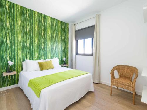 sypialnia z łóżkiem i zieloną ścianą w obiekcie Mahostly Apartamento Comillas SE w mieście Arrecife