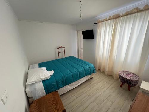 a bedroom with a bed with a green blanket at Casa centro de Caldera in Caldera