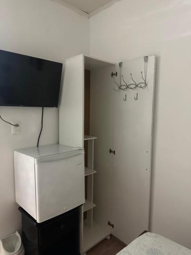 um quarto com um armário branco com uma televisão em Hostal Compostela Inn em David