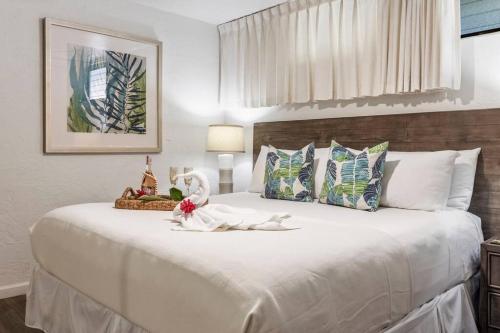 a bedroom with a large white bed with flowers on it at Papakea E206- Updated Papakea oceanview condo, all the amenities in Kahana