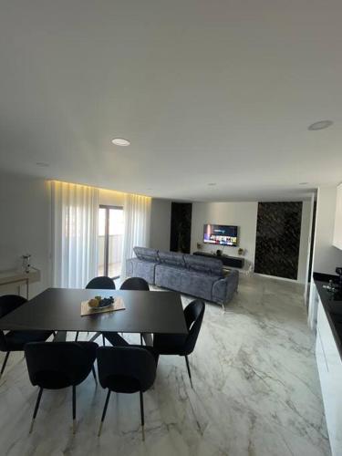 a living room with a table and chairs and a couch at Chez Alexandre - Magnifique Appartement - Ponte de Lima - Wifi Gratuit - Parking Gratuite in Cancinhola
