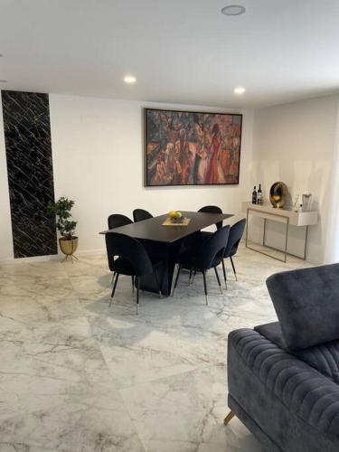 a dining room with a table and black chairs at Chez Alexandre - Magnifique Appartement - Ponte de Lima - Wifi Gratuit - Parking Gratuite in Cancinhola