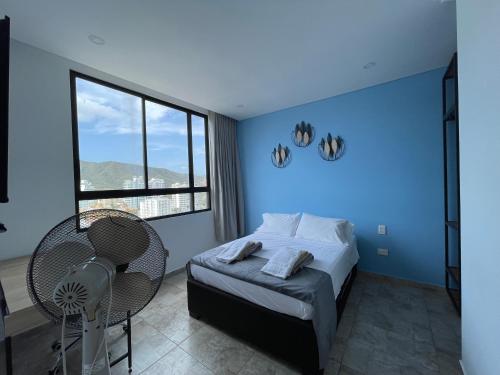 a blue bedroom with a bed and a chair at En el Rodadero Santa Marta apto Moderno con piscina,sauna,turco,Jacuzzi in Rodadero