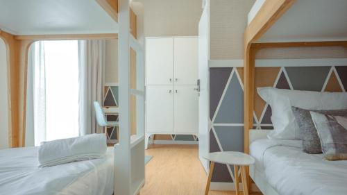 a bedroom with two bunk beds and a desk at Pedra de Sal - Hostel & Suites in Rio Maior