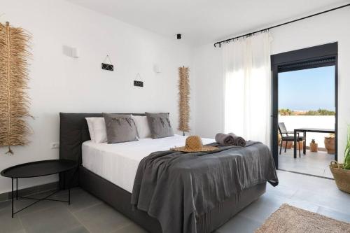 a bedroom with a large bed and a balcony at Seafish Villa, 2 Luxury Villas at Lachania Beach in Lachania