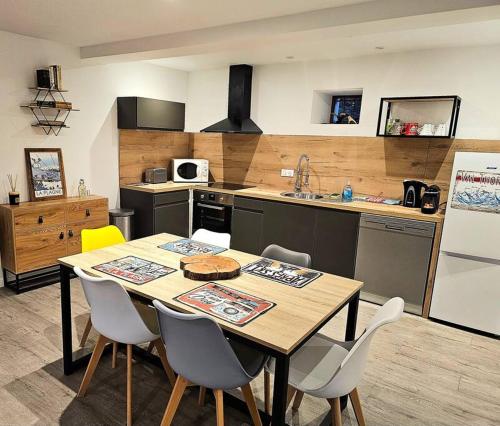 une cuisine avec une table et des chaises dans une cuisine dans l'établissement Appartement de 80m² plein sud entièrement rénové, à Aime La Plagne
