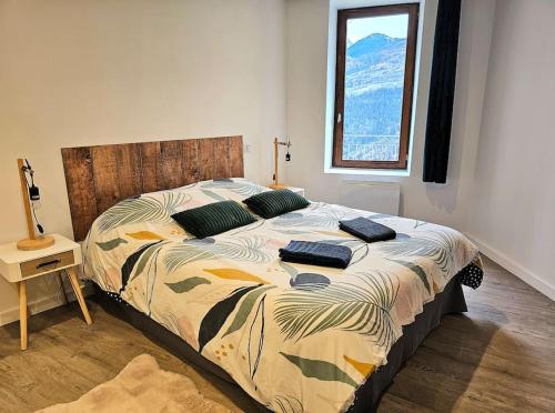 ein großes Bett in einem Schlafzimmer mit Fenster in der Unterkunft Appartement de 80m² plein sud entièrement rénové in Aime La Plagne