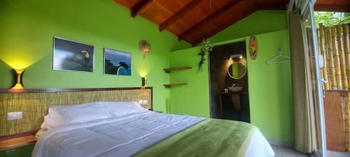 Schlafzimmer mit grünen Wänden und einem Bett mit weißer Bettwäsche in der Unterkunft Casita Maripier Colón 