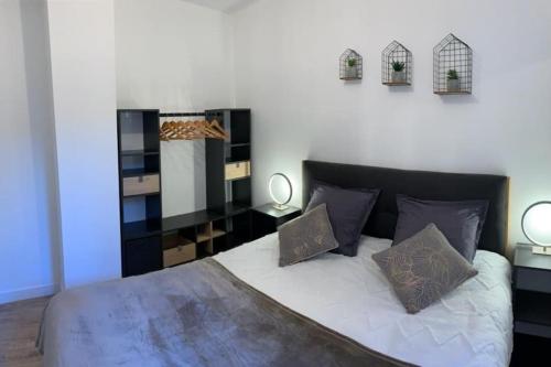 une chambre avec un lit avec deux oreillers et un miroir dans l'établissement Lumineux appartement Capitole plein centre, à Toulouse