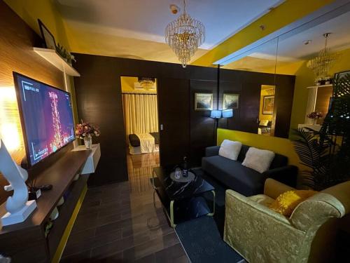 a living room with a couch and a flat screen tv at Luxurious stay at Air Residences in Manila