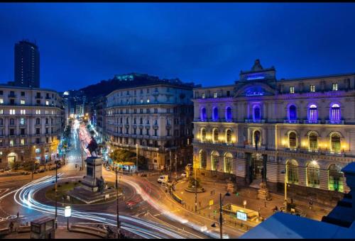 a city street at night with buildings and a statue at La Lepre Bovio in Naples