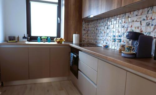 a kitchen with a counter and a sink and a window at 'Just like home' Apartment - with Private Parking Place in Galaţi