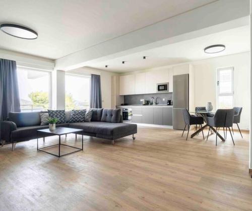 a living room with a couch and a table at SeaLife Grand Penthouse Varkiza in Vari
