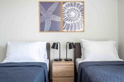 two beds sitting next to each other in a bedroom at SeaLife Grand Penthouse Varkiza in Vari