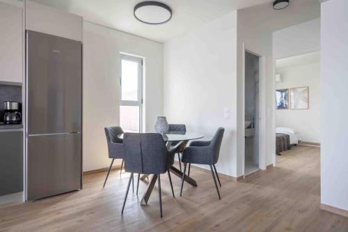 a kitchen and dining room with a table and chairs at SeaLife Grand Penthouse Varkiza in Vari