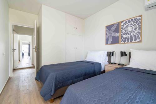 a bedroom with two beds and a hallway at SeaLife Grand Penthouse Varkiza in Vari