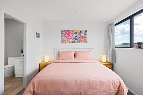 a bedroom with a bed and a window at Seaside Serenity at Bask Retreats in Mount Maunganui