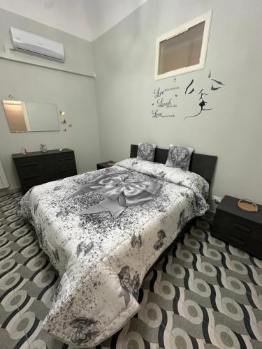 a bedroom with a bed with a comforter on it at Elisir house in Palermo