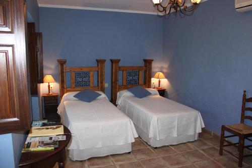 two beds in a room with blue walls at Mesa del Conde in San Felices de los Gallegos