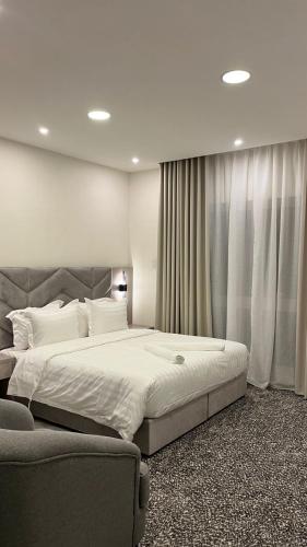 a bedroom with a large bed and a couch at جادا للشقق المخدومة Jada in Al Khobar