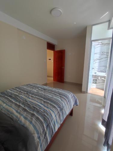 um quarto com uma cama e uma porta de vidro deslizante em Apartments em Chiclayo