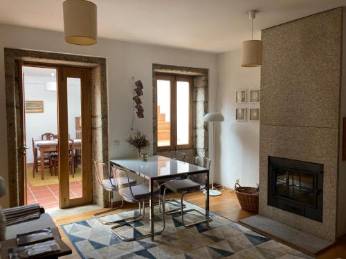 a living room with a table and a fireplace at A Avozinha - Arouca in Arouca