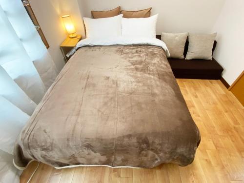a large bed in a room with a couch at 1min walk to sta, drct bus to HND! Easy access! 01 in Tokyo