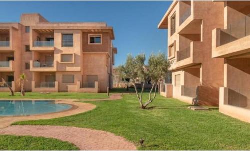 an apartment building with a yard with a swimming pool at Appartement de rêve à Marrakech in Marrakech