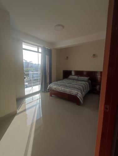 a bedroom with a bed and a large window at Apartments in Chiclayo