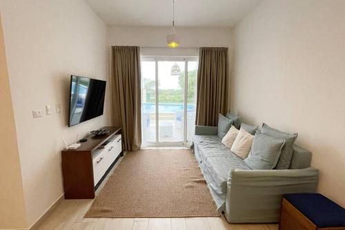 a living room with a couch and a tv at Apartamento de 2 Dormitorios en Hard Rock Golf in Punta Cana