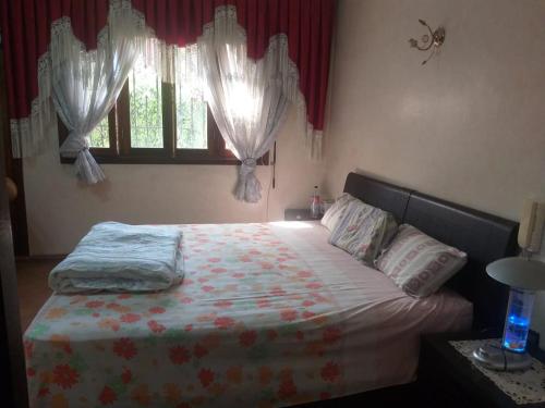 sypialnia z łóżkiem i oknem z zasłonami w obiekcie فيلا ممتازة مفروشة للايجار اليومي w mieście Kenitra