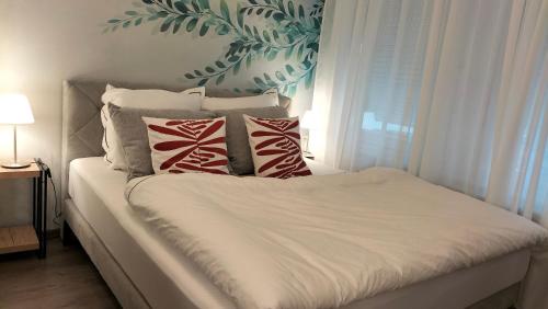 a bed with red and white pillows and a window at King Bed 4 people near Basel, Switzerland, Weil am Rhein, Loerrach, Germ'any, Near Airport in Saint-Louis