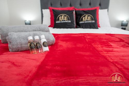 a bed with a red blanket and two bottles of alcohol at Hades Apartment - The Soul of Town in Southampton