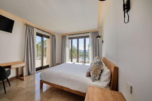 um quarto com uma cama e uma grande janela em Luxuriöse Villa mit Pool nahe Canyamel em Capdepera