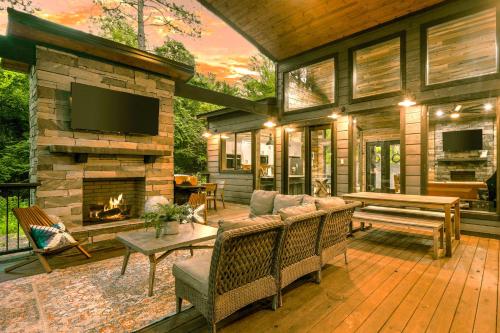 a screened in porch with a fireplace and a television at New Modern Farmhouse w Jacuzzi BBQ Arcade in Broken Bow