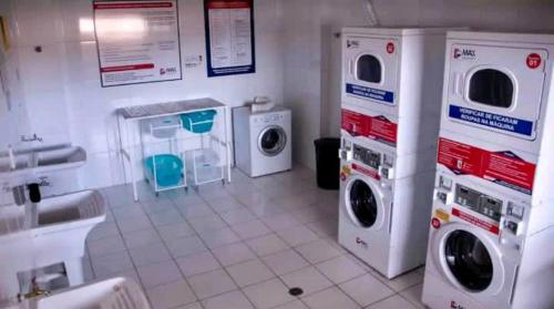 a laundry room with three washing machines and a sink at Apartamento 1445 Encantador in Ribeirão Preto