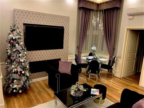 uma sala de estar com uma árvore de Natal e uma televisão em Danube Royal de Lux em Budapeste