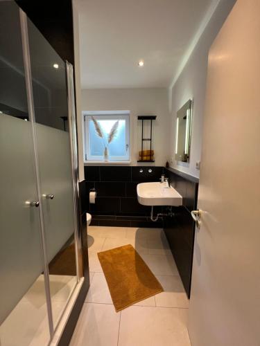 ein Bad mit einem Waschbecken und einem Fenster in der Unterkunft Ferienwohnung Aspelohe - Apartment 1 in Norderstedt