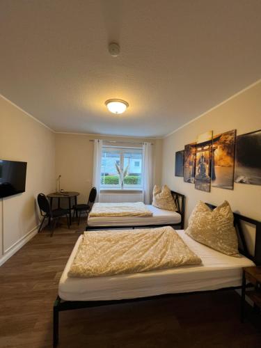 3 Betten in einem Zimmer mit Fenster in der Unterkunft Ferienwohnung Aspelohe - Apartment 1 in Norderstedt