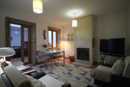 a living room with a tv and a fireplace at A Avozinha - Arouca in Arouca