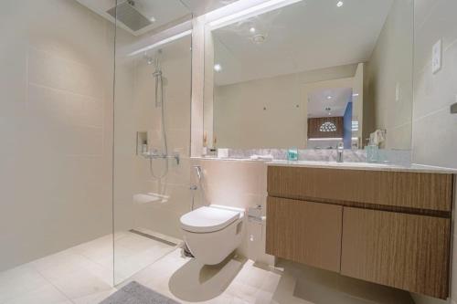 a bathroom with a toilet and a glass shower at The great house in Dubai