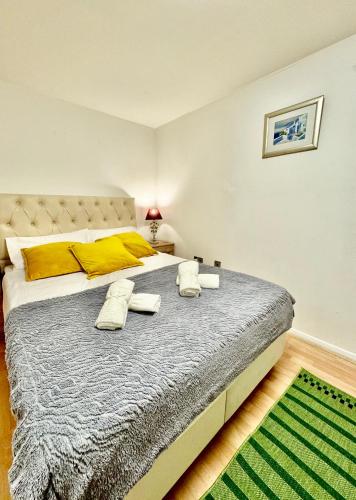 a bedroom with a large bed with yellow pillows at NewDay Property - Chelsea in London