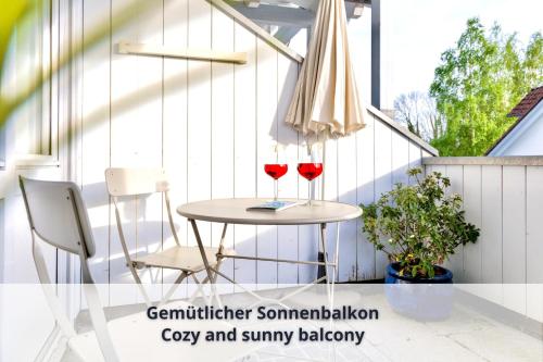 two glasses of red wine sitting on a table on a patio at Auszeit Apartment LAKEFRONT in Friedrichshafen