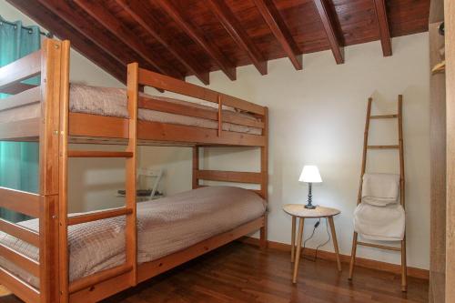 a bedroom with two bunk beds and a chair at Capelas Blue , Relax & Fun - Up to 14 Guests! in Ponta Delgada