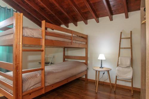 una camera con 2 letti a castello e una sedia di Capelas Blue , Relax & Fun - Up to 14 Guests! a Ponta Delgada