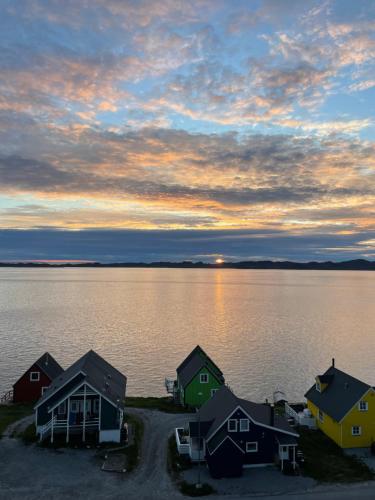 un grupo de casas en la orilla de un cuerpo de agua en The White House en Nuuk