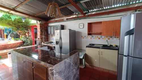 a kitchen with a refrigerator and a counter top at Hostal Villa Aurora in Roldanillo