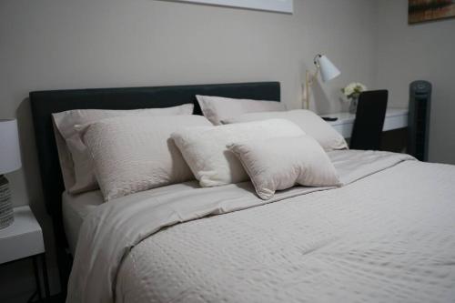 a white bed with white pillows on top of it at New Suite 15min from DT Van & Skytrain + Parking in Vancouver